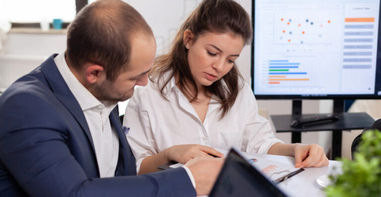 Empresários analisando relatórios e gráficos com apoio da contabilidade consultiva