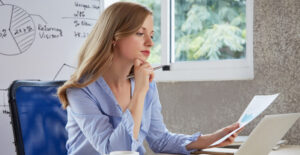 Empresária analisando dados financeiros para evitar multas e problemas com o fisco